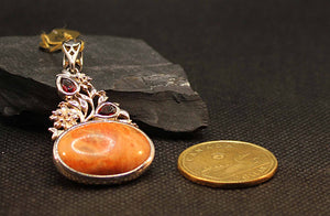 Bamboo coral pendant with garnets set in sterling silver