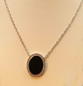 Sterling silver with rhodium finish smooth oval pendant surrounded by cubic necklace