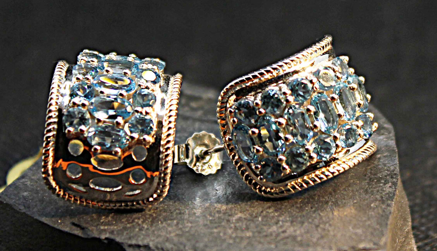 Wide hoop style earrings in sterling silver multi-set with genuine blue topaz